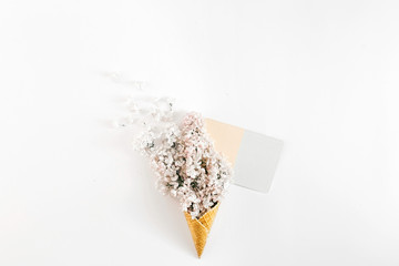 Top view ice cream cone branch white lilacs empty card white background Minimal spring concept Flat lay