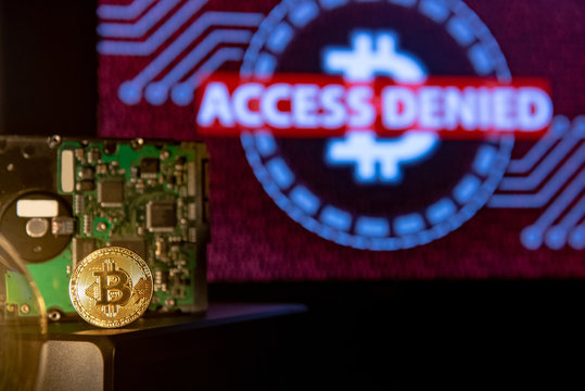 Bitcoin gold coin with hard disk drive and red binary screen in the background. Cryptocurrency crisis or digital currency access denied concepts