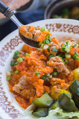 Soy meat with salsa ketchup hot sauce. Woman hands holds stewed, steamed, cooked veggies. Lunch, dinner new potatoes, eggplant, spinach leaves with garlic and herbs.  Raw vegan vegetarian healthy food