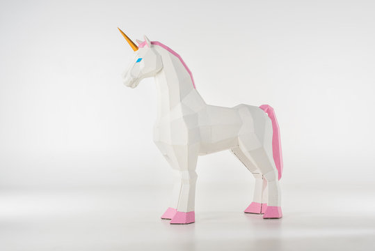 unicorn toy with golden horn with pink hooves on white