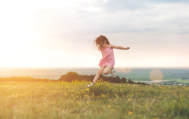 Pretty little girl jumping outdoors