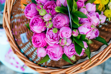 Beautiful magenta roses flower bouquet in the wicker basket. Spotted on the flower market.