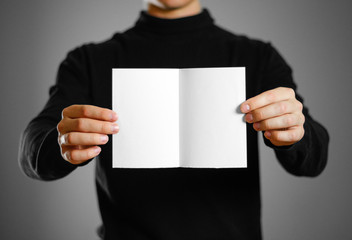 Man showing blank white flyer brochure booklet. Leaflet presentation. Pamphlet hold hands. Man show clear offset paper