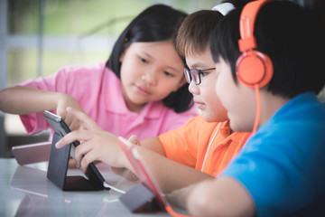 Asian child playing tablet computer together