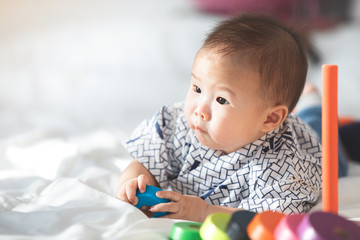 Asian baby boy playing on the bed.