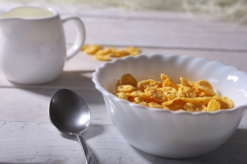 Corn Flakes cereal in a bowl and glass with milk. Morning breakfast.
