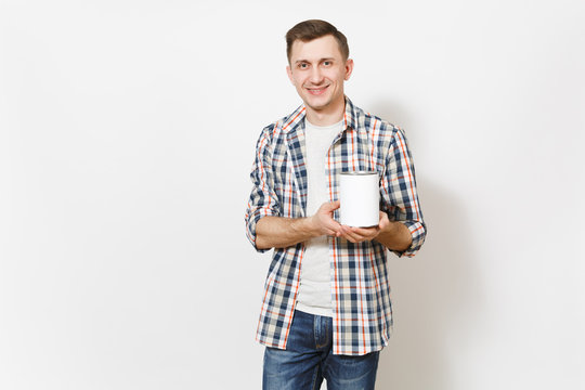 Young smiling handsome man in casual clothes holding empty paint tin can with copy space isolated on white background. Instruments, accessories for renovation apartment room. Repair home concept.