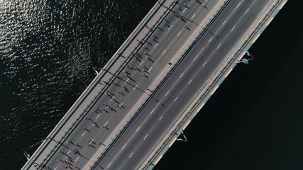 4K Aerial drone fooage. Marathon running on the bridge. Camera rotate top view