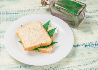 Marijuana and food. A sandwich with marijuana leaves. The use of cannabis in the manufacture of food. The concept of increasing appetite after consuming marijuana.