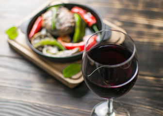 A glass of wine on a background of eating on a dark wooden background.