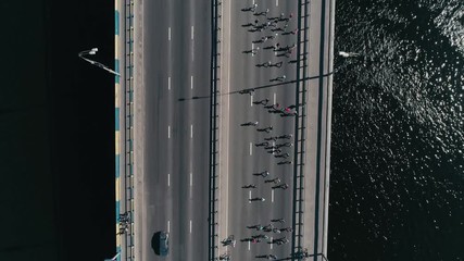 4K Aerial drone fooage. Marathon running on the bridge. Vertical dolly shot top view