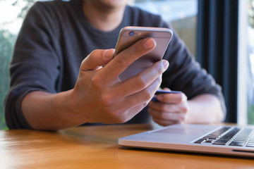Man holding credit card and using smartphone,onine shopping, online payment.