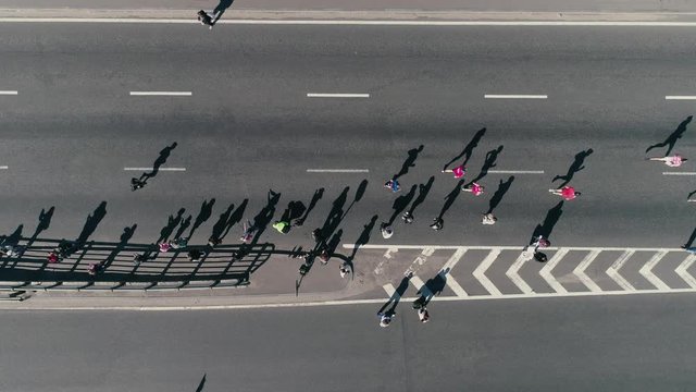 4K Aerial drone fooage. Marathon running on street. Group of support. Top view