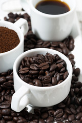 Three types of coffee - ground, grain and beverage in white cups , vertical