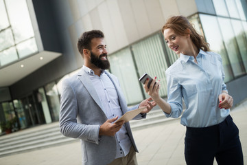 Young business couple walking outdoor near office building