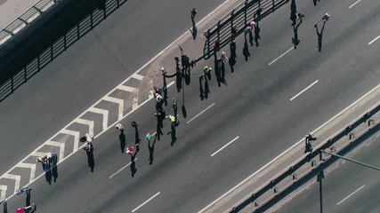 4K Aerial drone fooage. Marathon running on street. Group of support. Camera rotate. Top view