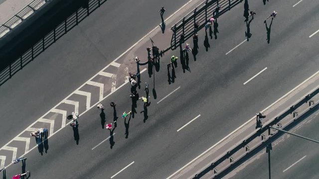 4K Aerial drone fooage. Marathon running on street. Group of support. Camera rotate. Top view