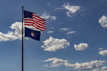 National flag of the United States of America, and the Utah Stage Flag, against a blue sky with scattered clouds. 