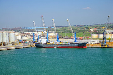 Freighter in working container harbor