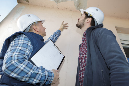 builder inspecting roof damage