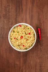 Overhead photo of noodles with a chili pepper and place for text