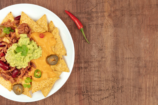 Closeup of nachos with cheese and chilli, traditional Mexican snack, with place for text