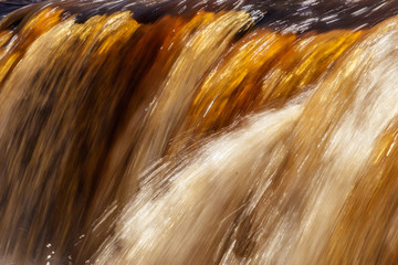 Latvia.pa green coast with old trees floods river with Irving Falls