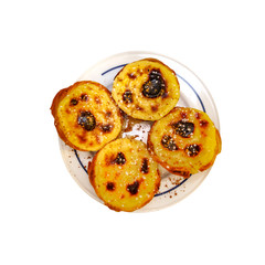 Top view of plate with pasteis de nata on white
