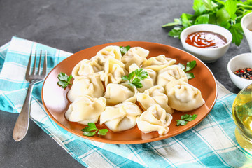 Homemade ready dumplings on a gray concrete table.