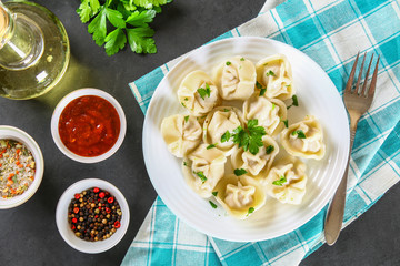 Homemade ready dumplings on a gray concrete table.