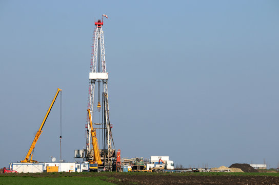 land oil drilling rig and cranes heavy machinery in the field