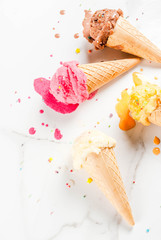 Homemade berry vanilla caramel chocolate ice cream in waffle cones, white marble background copy...
