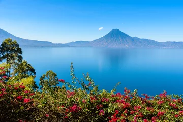 Tuinposter View from Lake Atitlan in the early morning, blue skys and clear water, beautiful magic lake with volcanos and indigenous people in the highland of Guatemala  © Simon Dannhauer