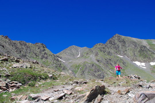 Jeune et jolie fille en pull rose en montagne en France au Carlit