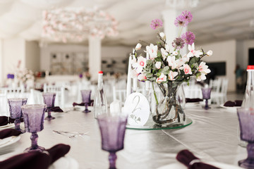 Photo of beautiful table setting and bouqet in center at wedding hall isolated