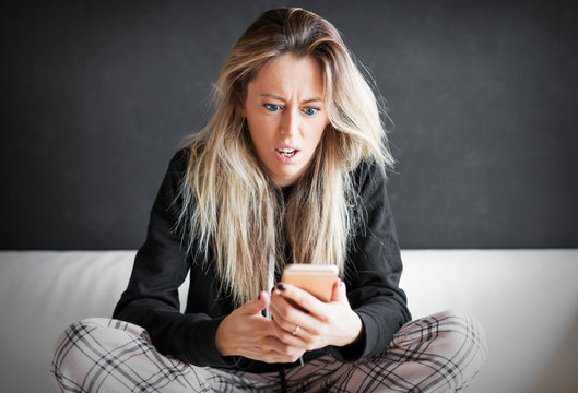 Angry woman holding mobile phone