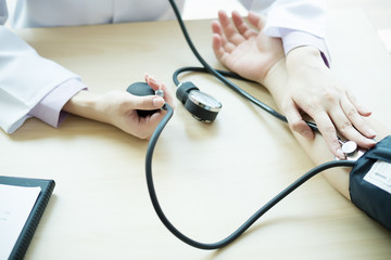 Doctor measuring patient arterial blood pressure. Health care,hospital and medicine concept - doctor and patient measuring blood pressure