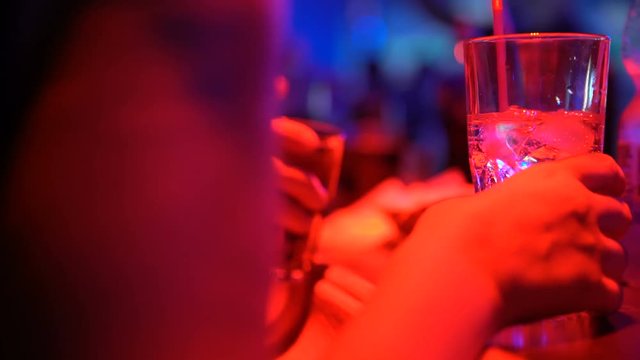 Female drinking cocktail and talking with friend at bar counter in pub, closeup