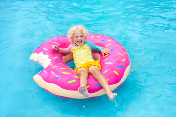 Child in swimming pool on donut float