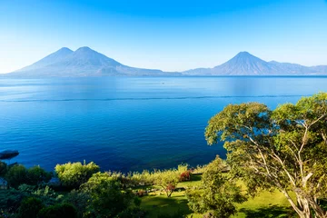 Fotobehang View from Lake Atitlan in the early morning, blue skys and clear water, beautiful magic lake with volcanos and indigenous people in the highland of Guatemala  © Simon Dannhauer