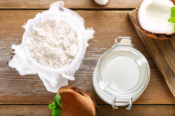 Squeezing milk from the chips of coconut in the gauze on an old wooden table.