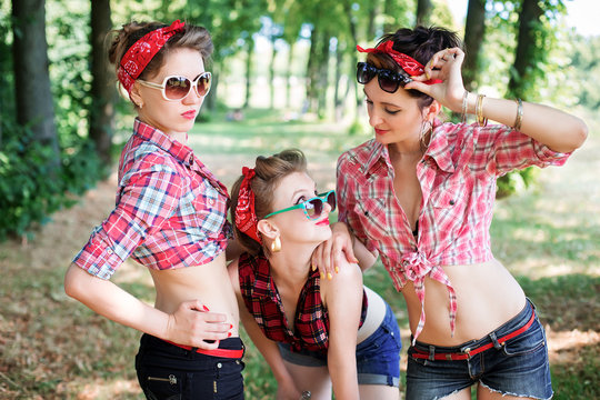 Group of friends at park having fun party. Rockabilly hen-party in park. Portrait of smiling girls wearing glasses