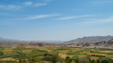 Fototapeta na wymiar Rural landscape with fields seen from abandoned mud brick village of Kharanaq in Iran