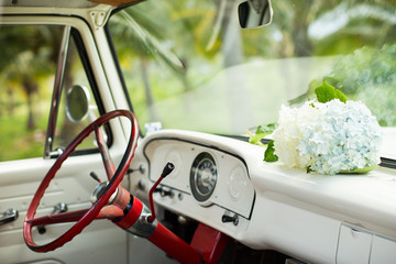 Classic car interior with white flowers red steering wheel