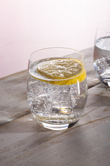 Sparkling mineral drink water in glasses served on table with lemon copy space