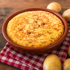 Traditional spanish omelette close up,  view from above. Spanish tortilla on a rustic wooden texture with a place for text.