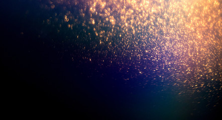 Golden glittering magic lights abstract background with gold particles. Christmas, festive, party...