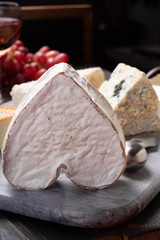 French cheeses plate in assortment,  Neufchatel heart shaped aged white cow cheese from Normandy