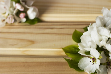 White apple blossoms with green leaves on a wooden background, texture, background, copy space, space for text