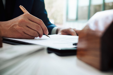 Fototapeta premium Close up of business person hand putting signing contract,running own small business,have a contract in place to protect it,signing of modest agreements form In office